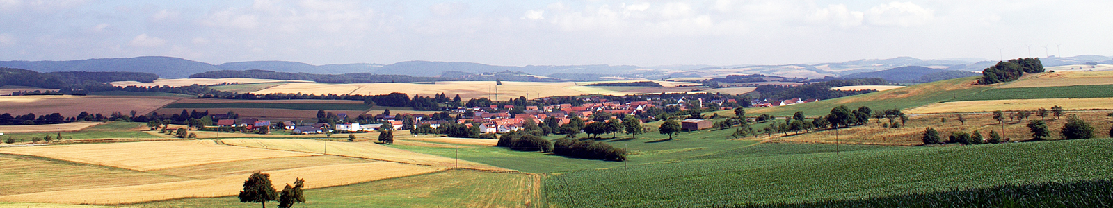 Weitläufiges Landschaftsbild mit Dorf, Hügeln und Feldern ©Feuerbach